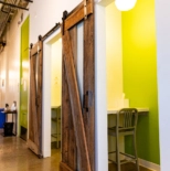 Small private call booth rooms with a desk, chair and rustic barn doors