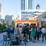 Group of people gathered outside in a modern rooftop lounge