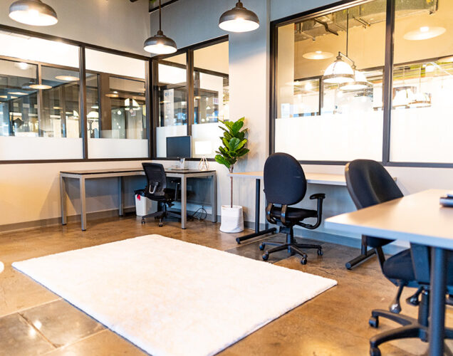 wide view of an office featuring desks and chairs