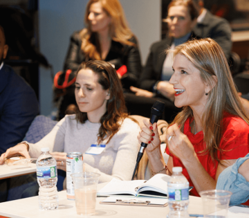 two women sitting at a conference laughing