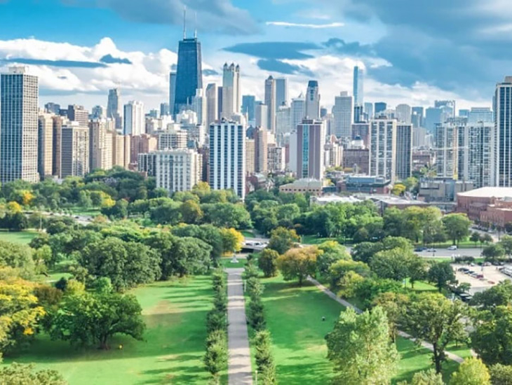 aerial shot of a garden with a pathway, with a skyline view of downtown chicago in the distance