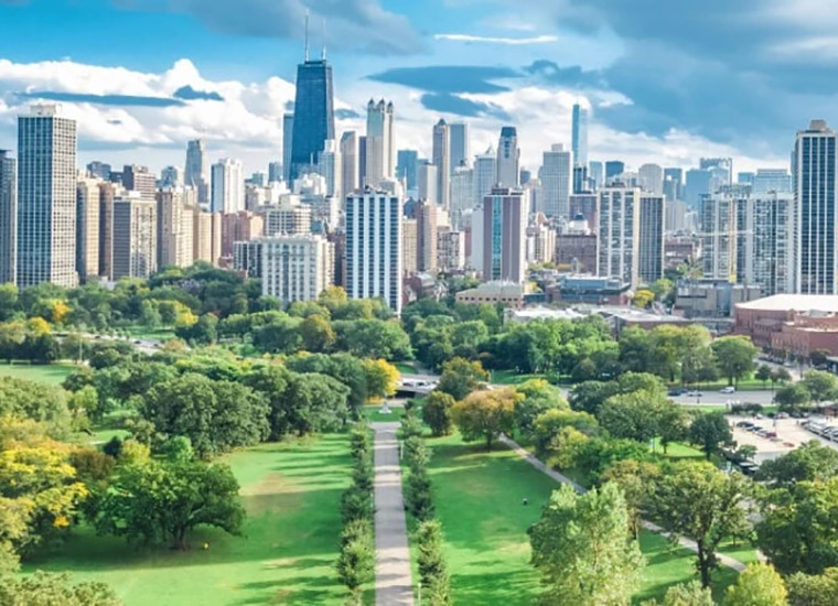 aerial shot of a garden with a pathway, with a skyline view of downtown chicago in the distance