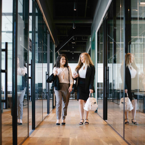 working womens walking and talking in office