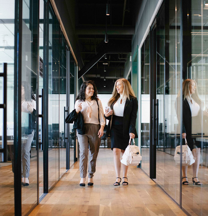 working womens walking and talking in office