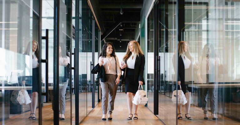 working womens walking and talking in office