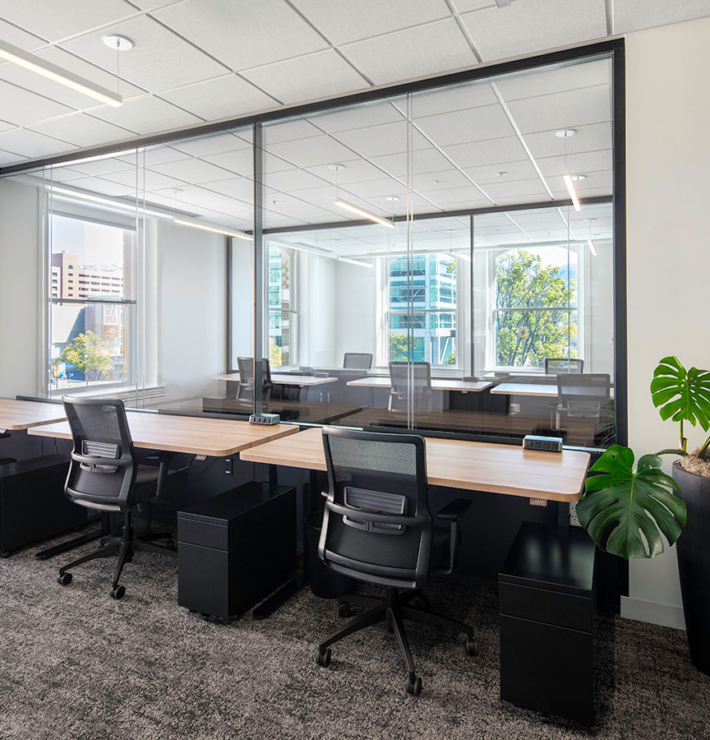 desks with chairs near a large office window