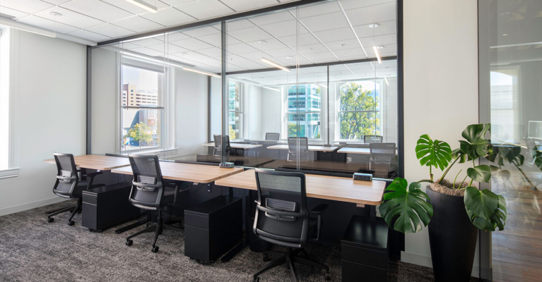 desks with chairs near a large office window